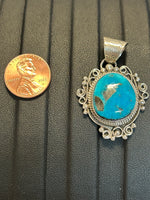 Navajo handcrafted sterling silver pendant with genuine turquoise stone.  LZ302