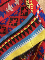 Close-up of a colorful fabric with geometric patterns in red, blue, black, and yellow.