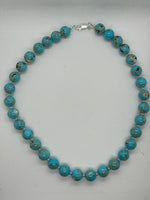 Turquoise (restructured blue) 12 mm stone necklace with sterling silver saucer beads, 20” long.  SR2083 FREE SHIPPING IN THE CONTINENTAL USA.