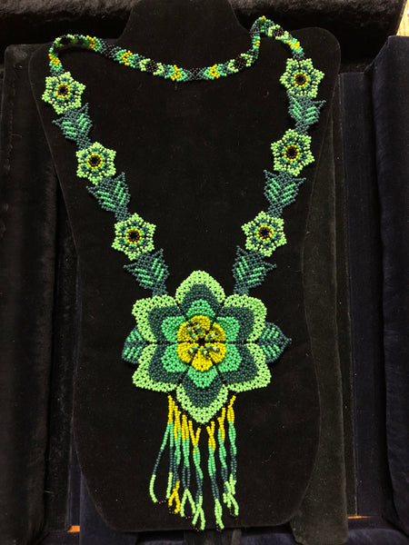 Several shades of green in a floral necklace made from seed beads.
