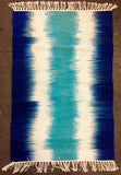 Blue, white, and turquoise tie dye ikat style rug in wool