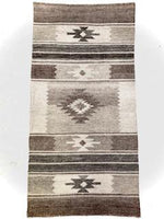 This handwoven rug is a design inspired by Navajo rugs.  It has several tones from the lightest grey to a medium grey.