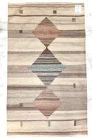 This hanwoven rug was made from recycled water bottles.  It has a background of brownish grey tones with thee diamonds, one being light blue and two a brownish mauve.
