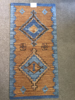 Rust and blue area rug that is handwoven.