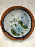 Ken Edwards Stoneware Pottery buffet plate with green, two shades of blue and brown flowers, birds, and butterflies decorated on the side or inside on bowls or plates