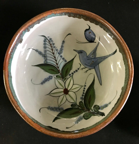 Hand thrown bowl decorated inside and out with birds, flowers, butterfly, with brown rim
