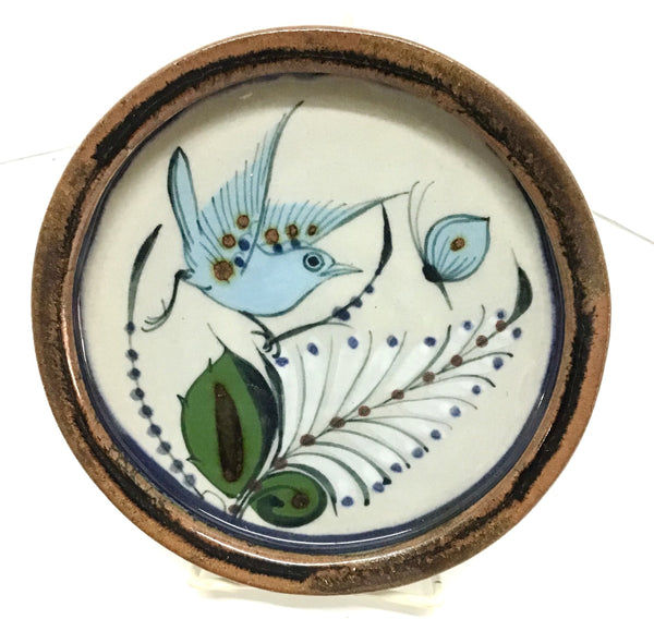 Ken Edwards Pottery trivet with brown trim and bird and butterfly and leaves in blue, green and black.