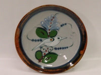 Ken Edwards Salad Plate 8.5" (P3) This plate is hand decorated and then fired at over 1,000 degrees in a kiln.  It is lead free and is decorated with flowers and a bird with leaves and has a brown rim.