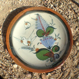 Ken Edwards regular series bread plate in 7" diameter.  The natural clay color, grey, has a brown rim with white black, blue and green birds and leaves and butterflies on the plate.