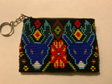 Handcrafted beadwork on both sides of change purse with 2 wolves