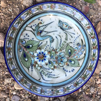  It is natural grey clay color background with birds, butterflies, and leaves in blue, green, black and brown on the outside.